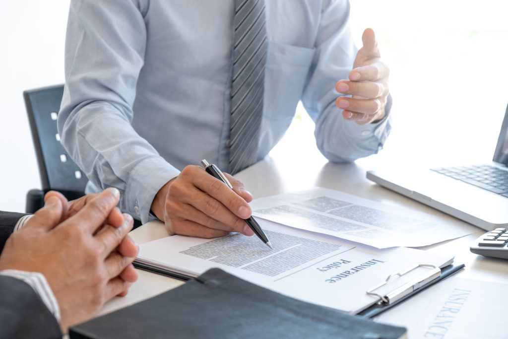 Customer reviewing and signing auto finance paperwork with a dealership representative, highlighting car loan options, flexible financing, and easy approval process.
